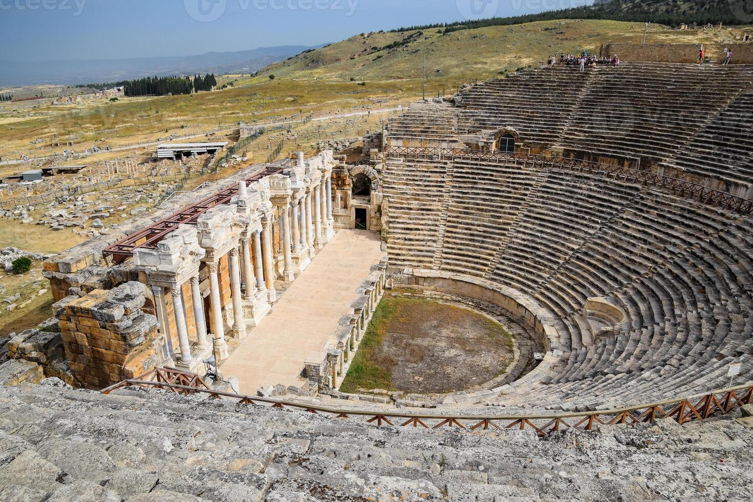 Ancient antique amphitheater in city of Hierapolis in Turkey. Steps and antique statues with columns in the amphitheater photo