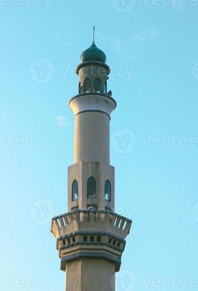 Mosque minaret in blue clouds photo