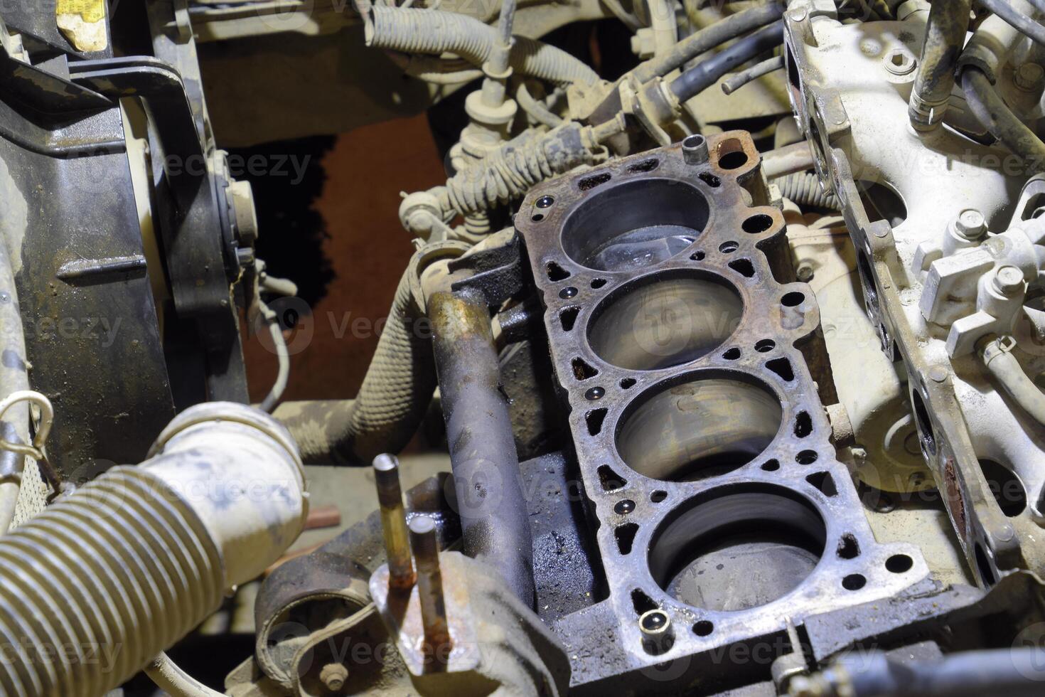 The cylinder block of the four-cylinder engine. Disassembled motor vehicle for repair. Parts in engine oil. Car engine repair in the service photo