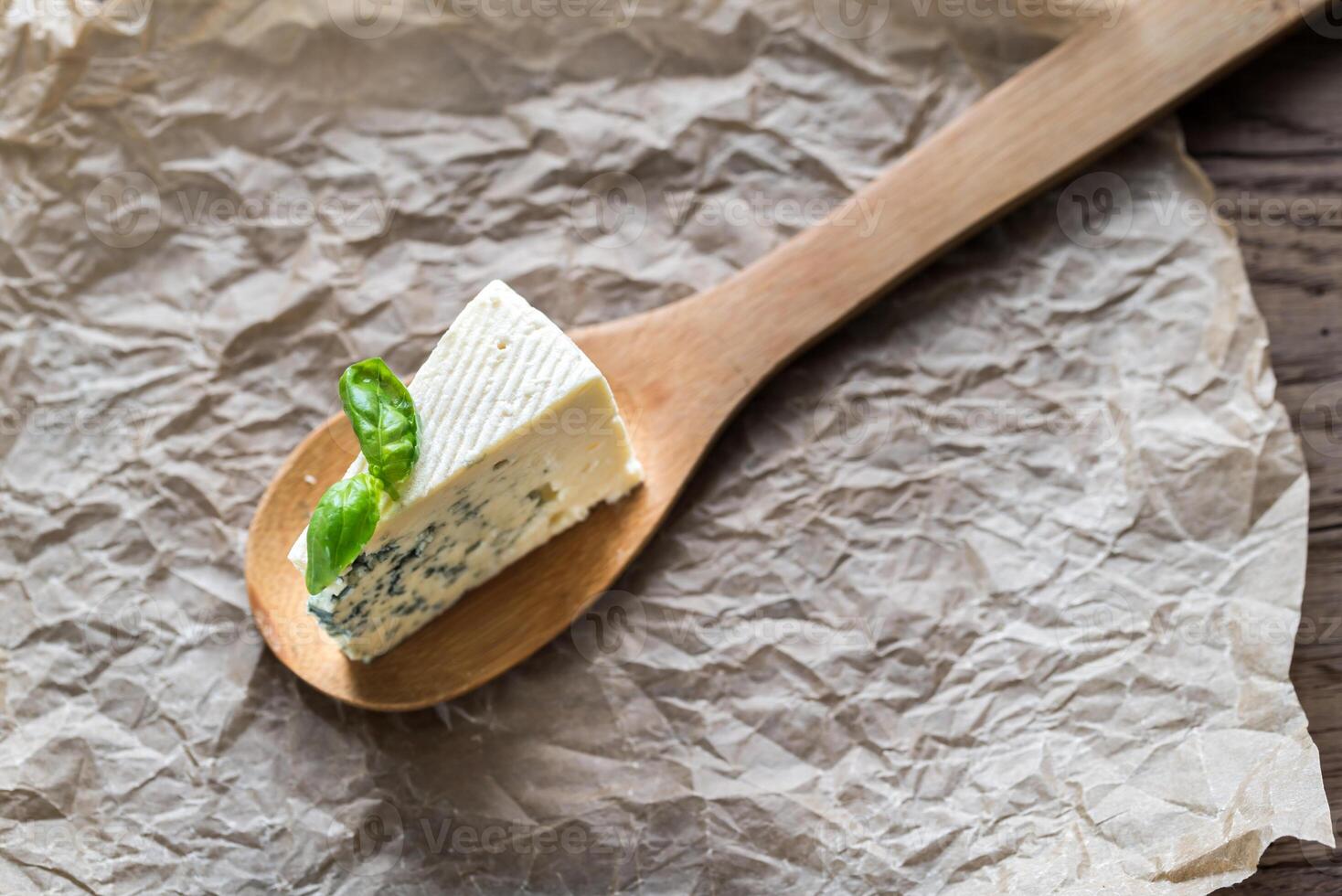 Piece of the blue cheese on the wooden spoon photo