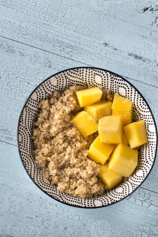 Portion of cooked quinoa with mango slices photo