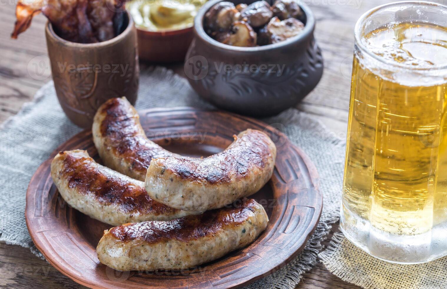 Grilled sausages with fried bacon rashers and mushrooms photo