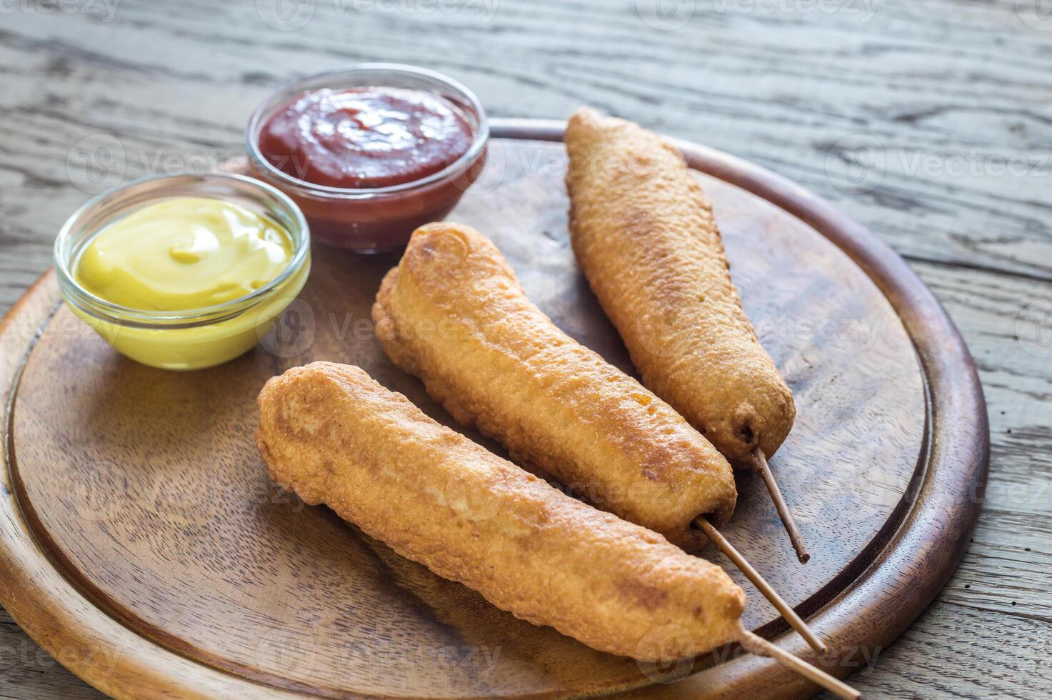 Stack of corn dogs on the wooden board photo