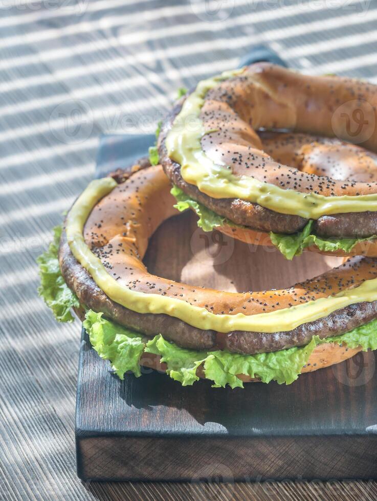 Bagels with fresh lettuce and fried sausage photo