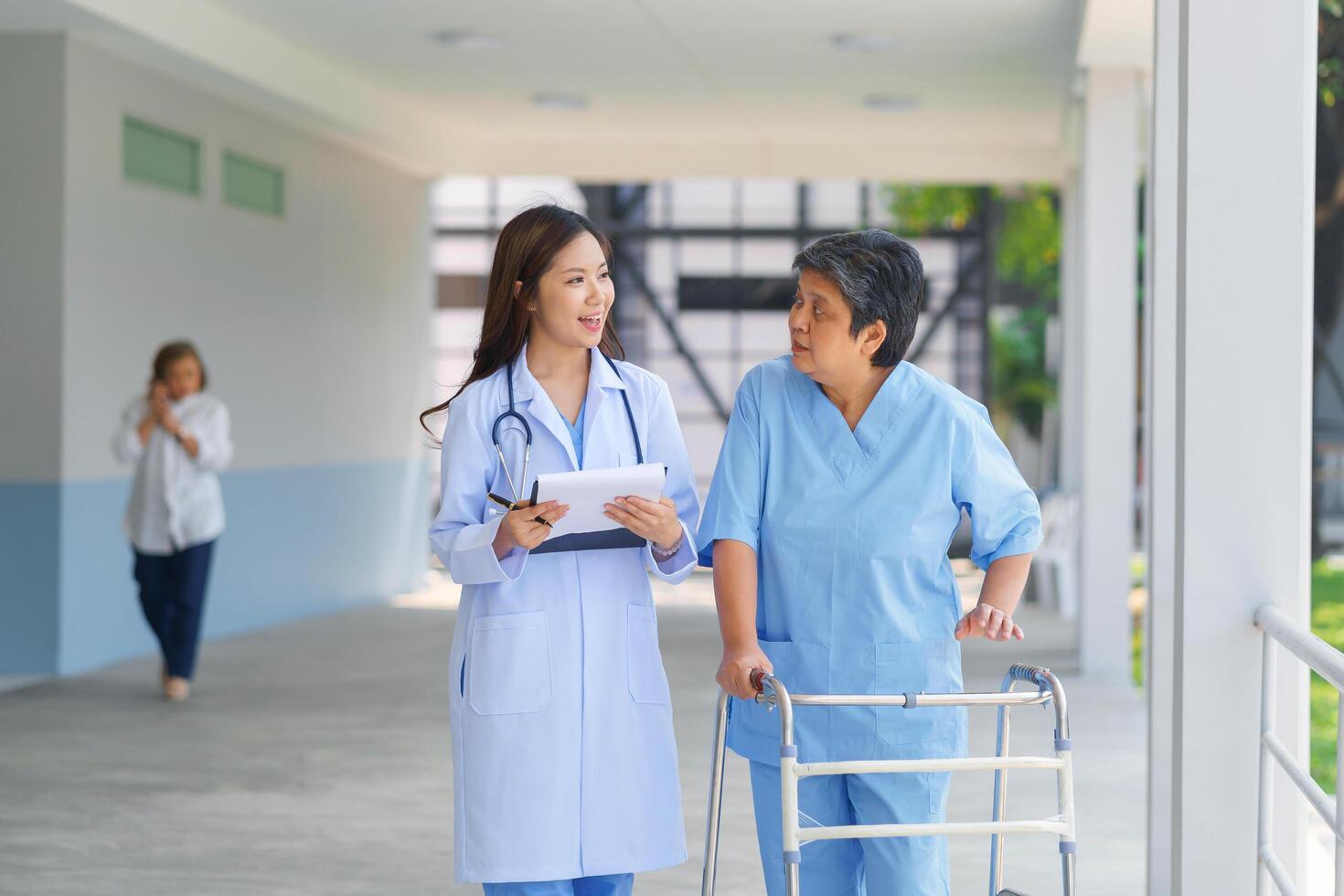 Smiling pretty caregiver and old lady with walking at hospital. concept healthcare photo