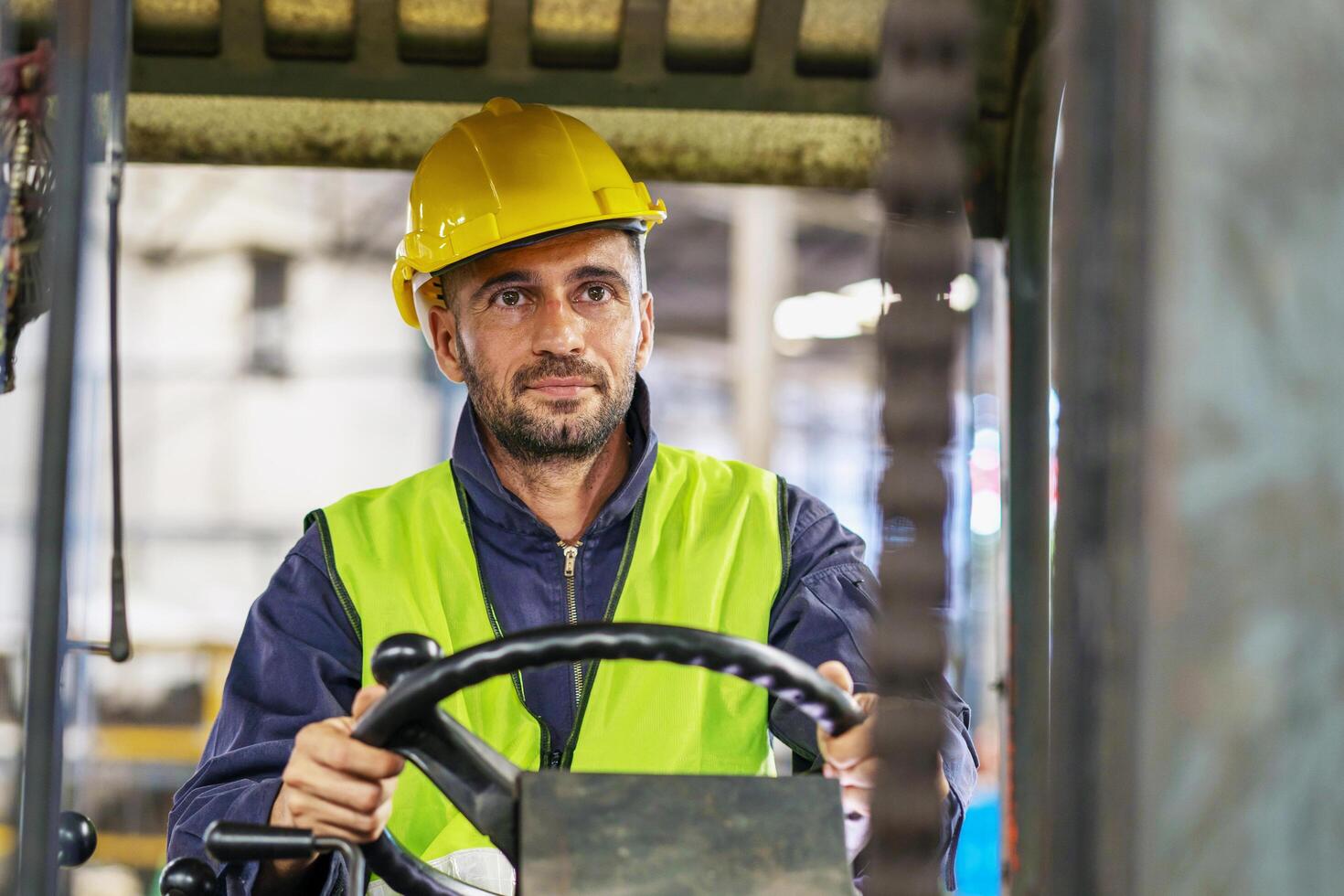 trabajador vistiendo casco con conductor máquina elevadora en almacén foto