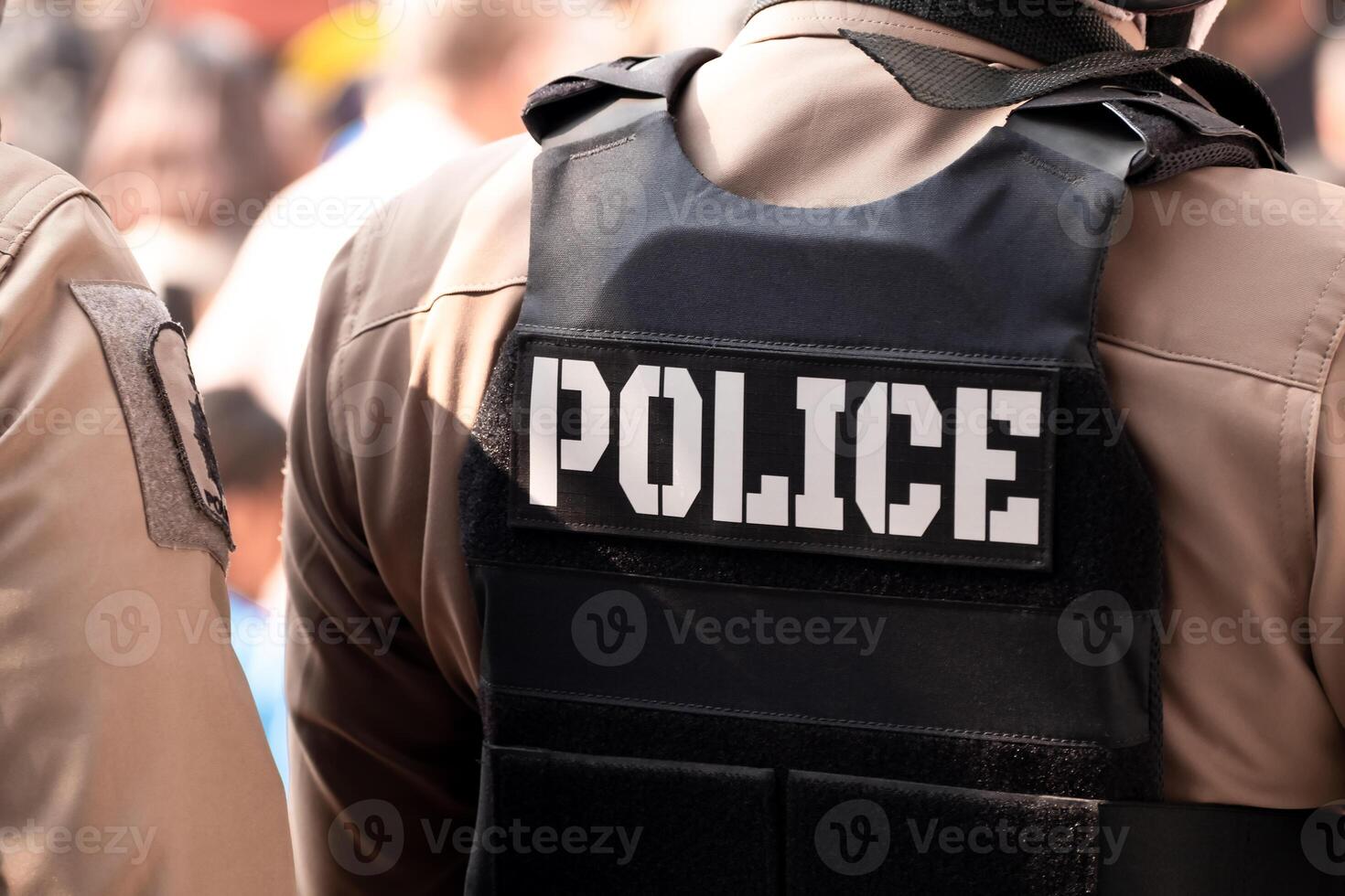 Back view of male police officer dressed. A bullet proof vest on his back spells out the word police. Thailand police uniform, Protection and maintenance of peace and order photo