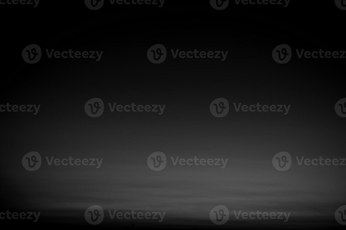 Dark black and gray blurred gradient background has a little abstract light. photo
