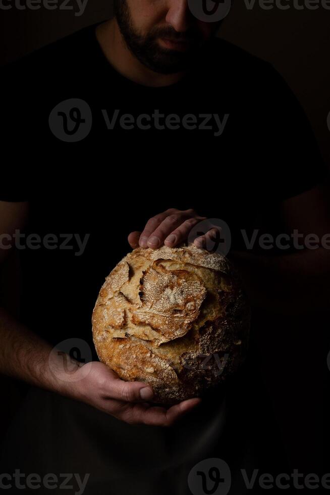 Attractive young Caucasian chef posing with white sourdough bread. photo