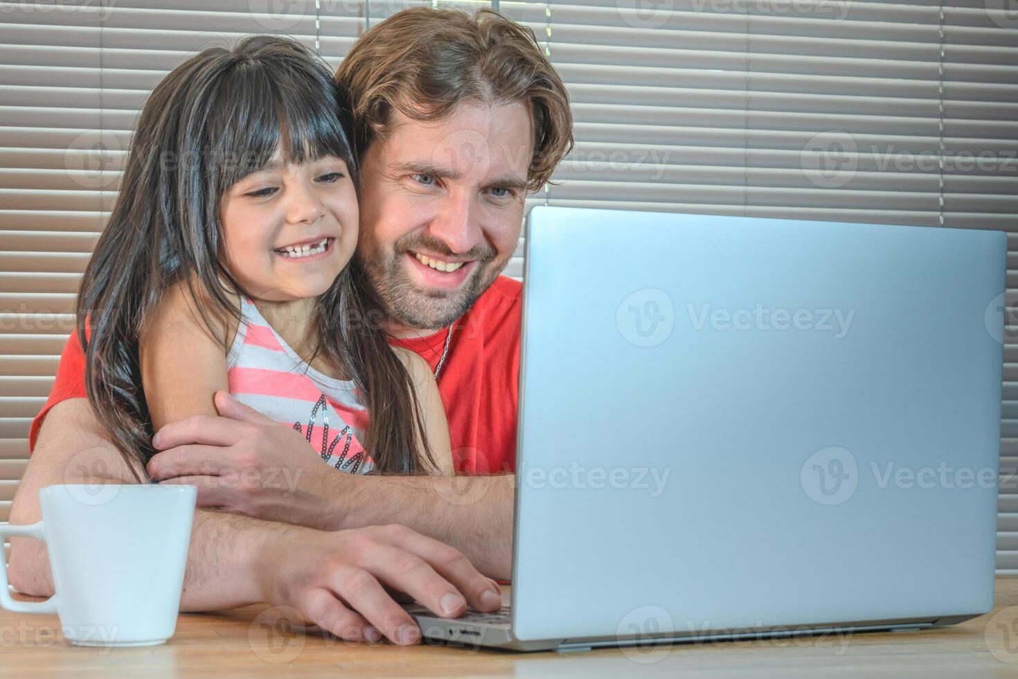 Portrait of a father and his daughter laughing in front of the computer. photo
