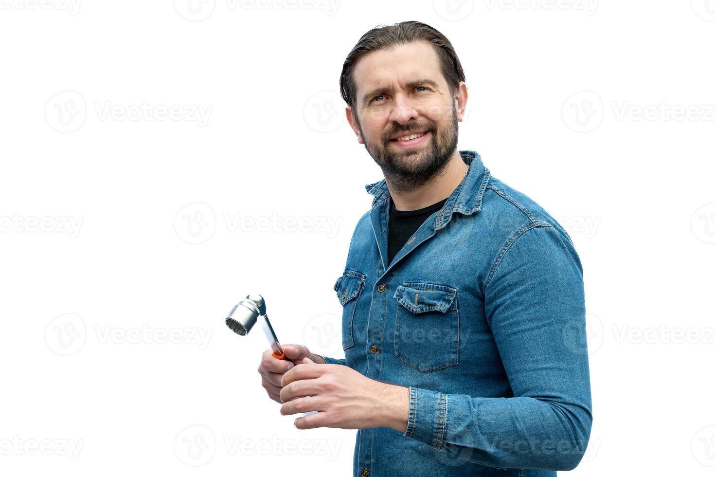 Argentinian mechanic posing on a white background while holding a tool. photo