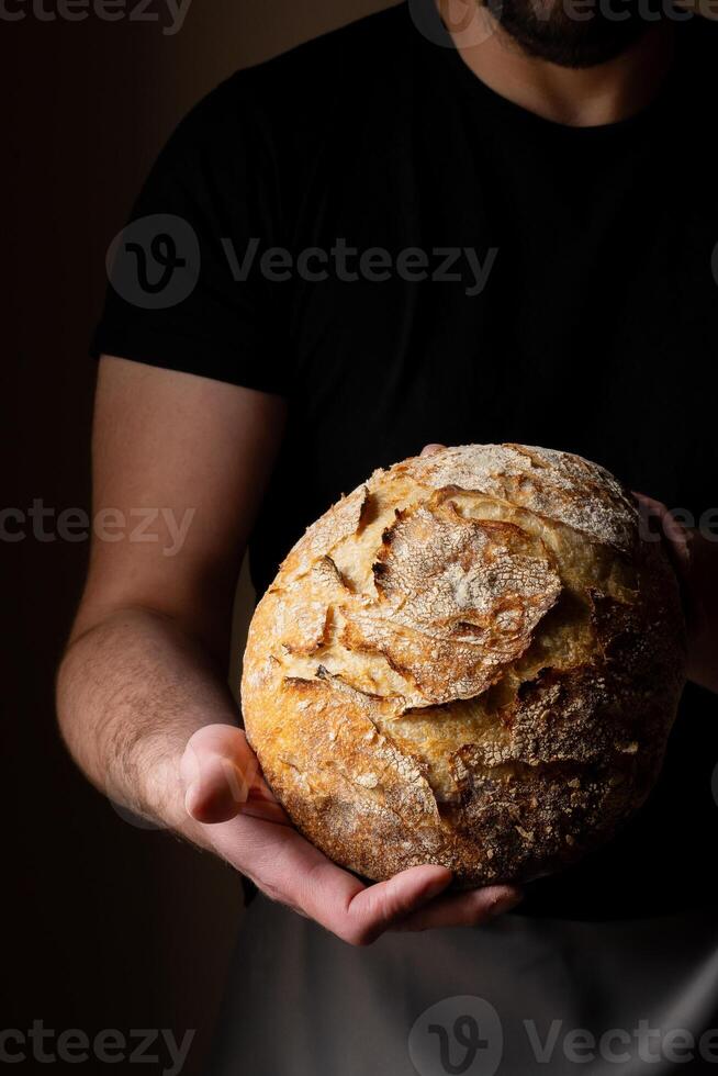 Attractive young Caucasian chef posing with white sourdough bread. photo