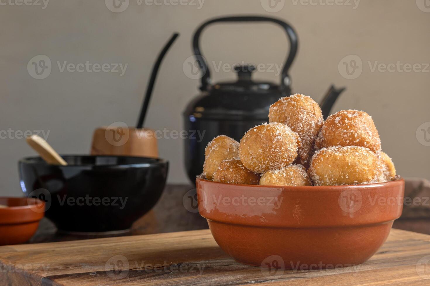 Argentine fritters coated in sugar accompanied by mate and kettle. photo