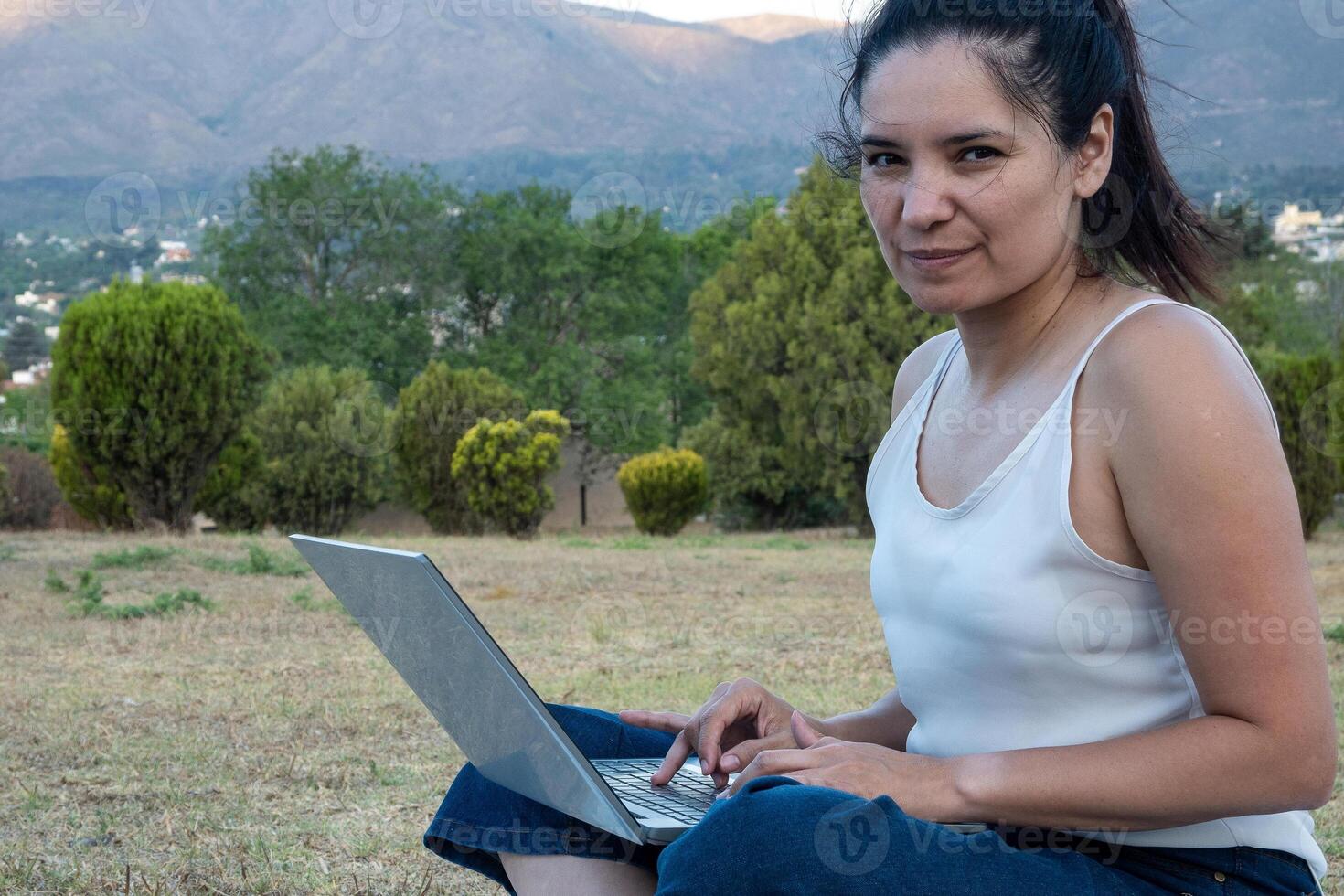 Latin girl went to the park to do her work. photo