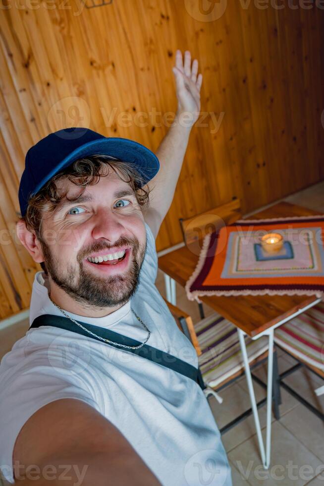 Selfie of a young tourist with a cap, entering his temporary apartment. photo