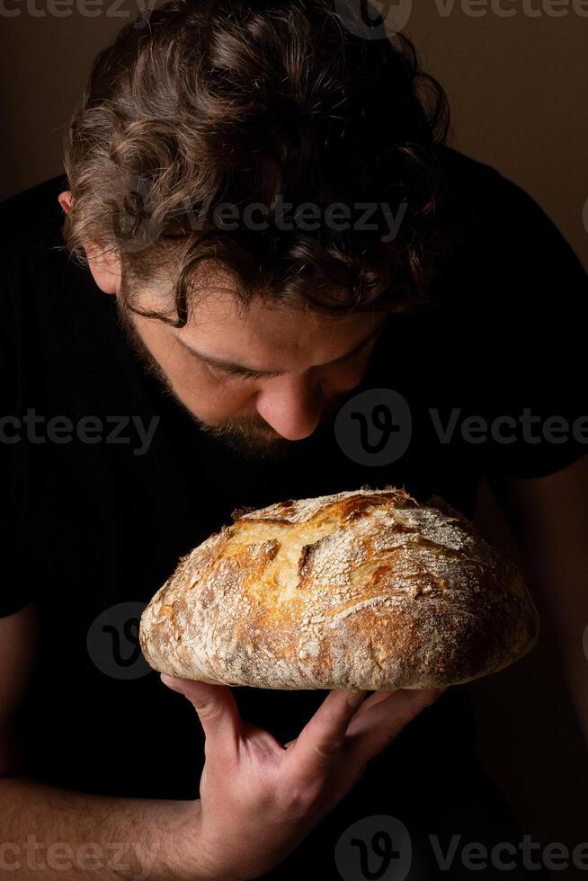 Attractive young Caucasian chef posing with white sourdough bread. photo