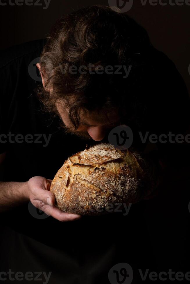 Attractive young Caucasian chef posing with white sourdough bread. photo