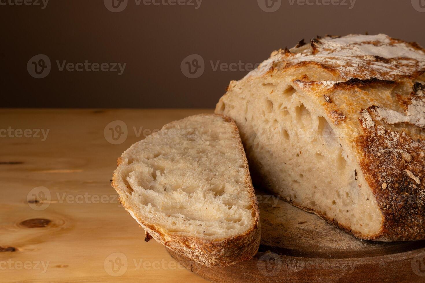 sano y muy crujiente de masa fermentada un pan descansando en un tablero. foto