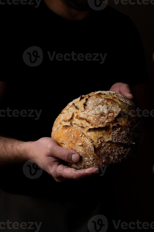 Attractive young Caucasian chef posing with white sourdough bread. photo