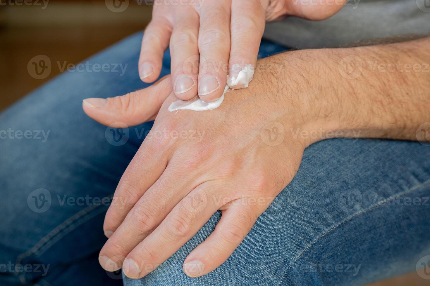 Hands of a man applying cream. photo