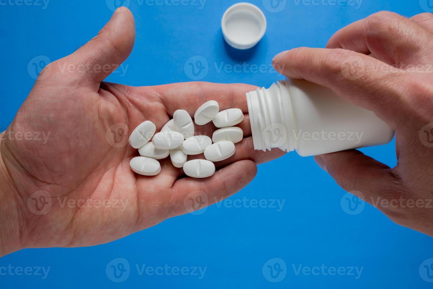 Hand pouring pills into the palm of the hand. photo