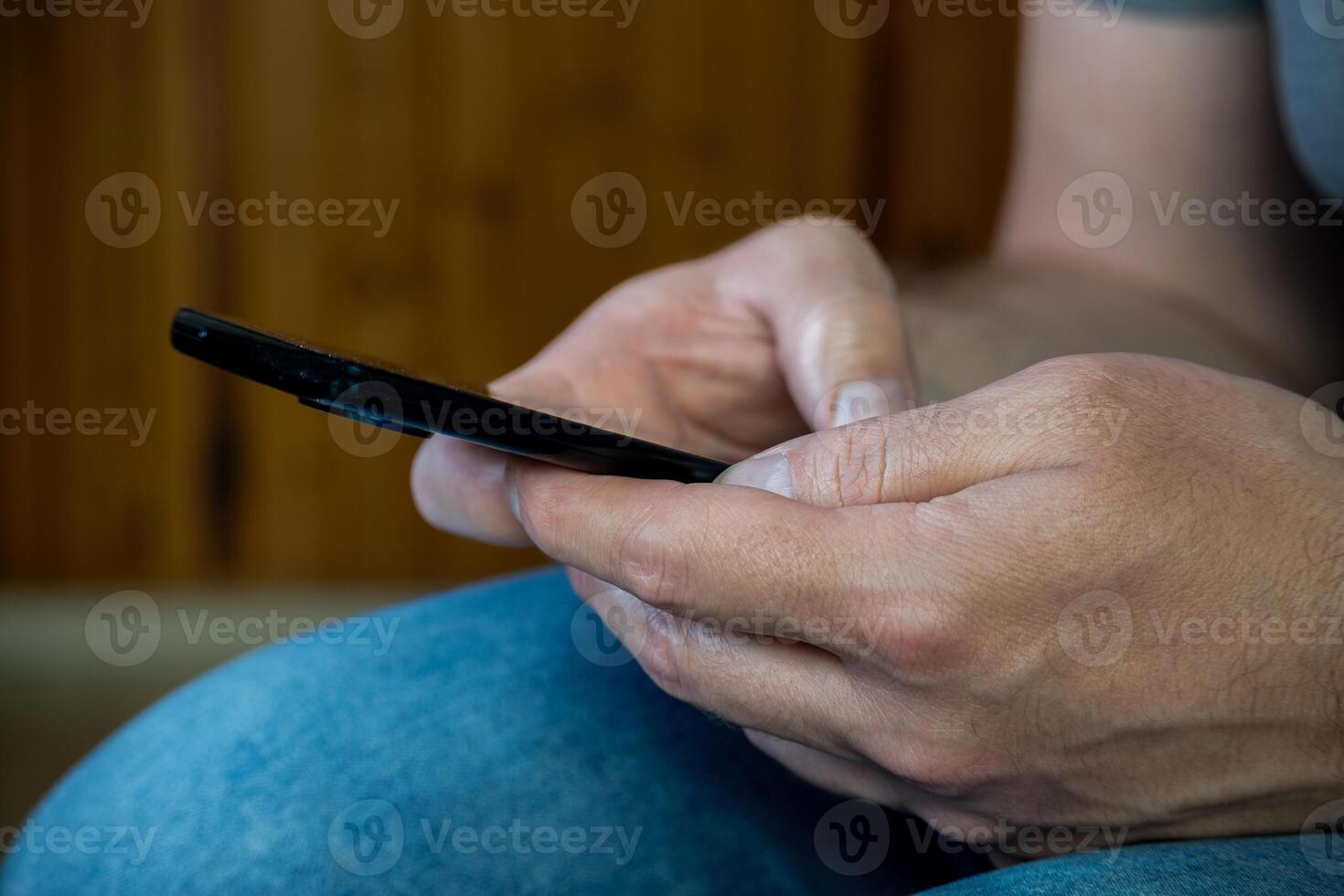 Man's hands from very close up using cell phone. photo