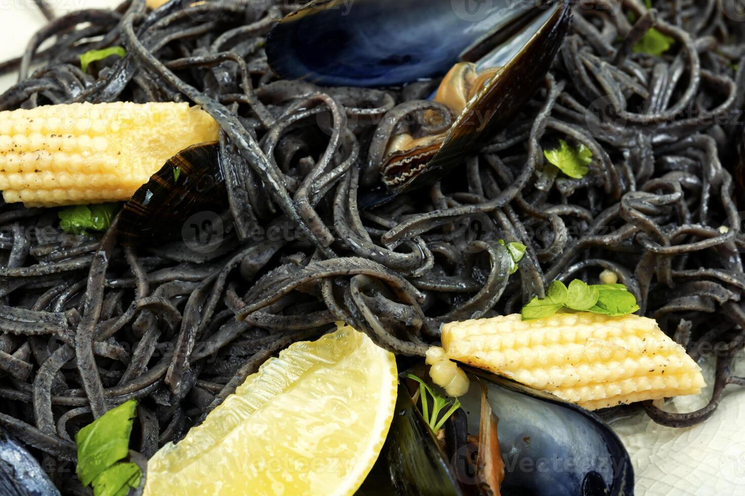 Black pasta with mussels and corn. photo
