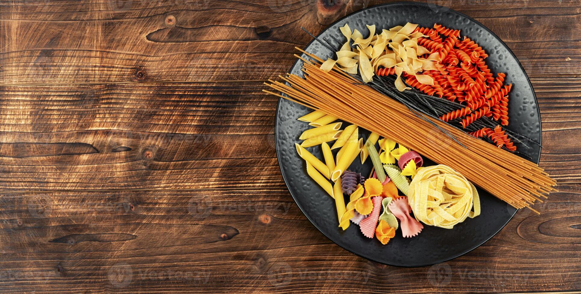Plate with raw pasta and macaroni. photo