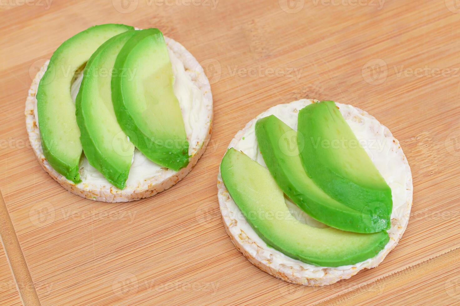 arroz pastel emparedados con Fresco aguacate y crema queso en bambú corte tablero. fácil desayuno. dieta alimento. rápido y sano sándwiches pan crujiente con sabroso relleno. sano dietético bocadillo foto