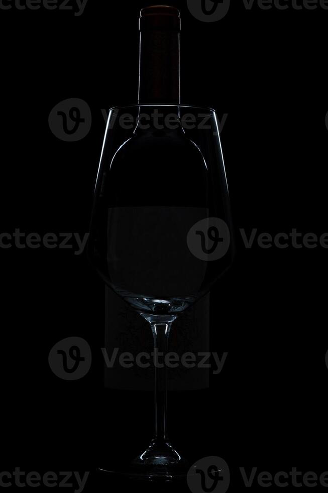 silhouette of wine glass bottle full of smoke in black background photo