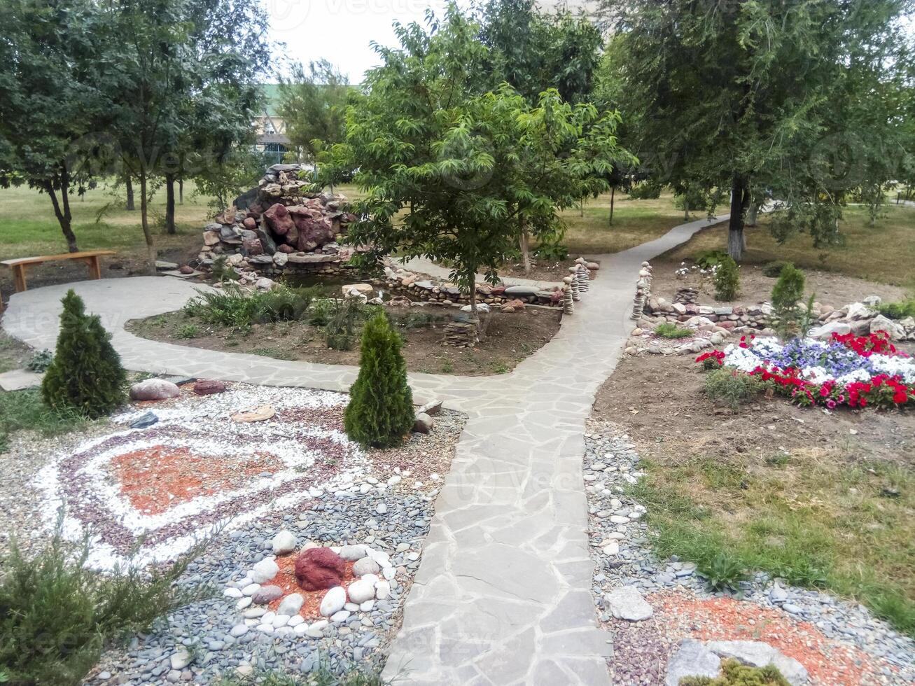 The flower bed is decorated with figures of stones of different colors. Hospital patio. photo