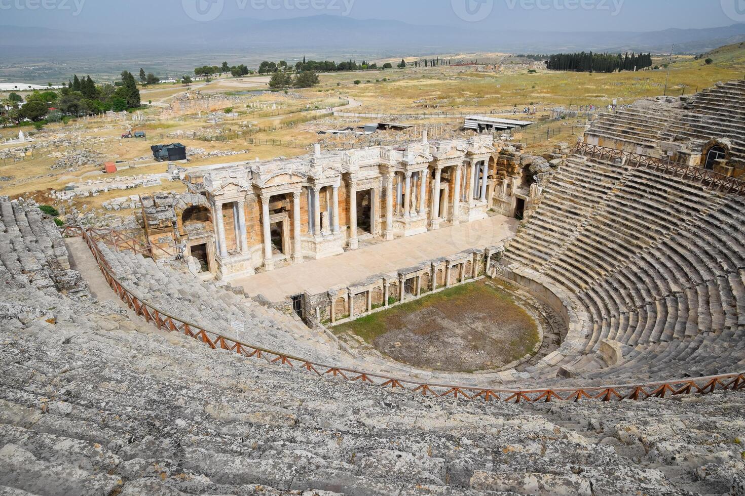 Ancient antique amphitheater in city of Hierapolis in Turkey. Steps and antique statues with columns in the amphitheater photo