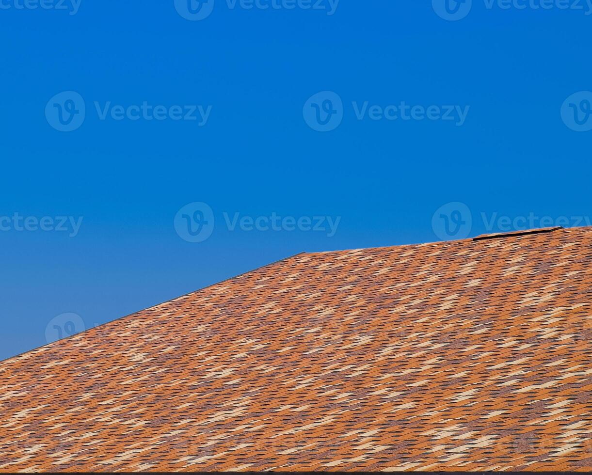 Roof from multi-colored bituminous shingles. Patterned bitumen shingles. photo