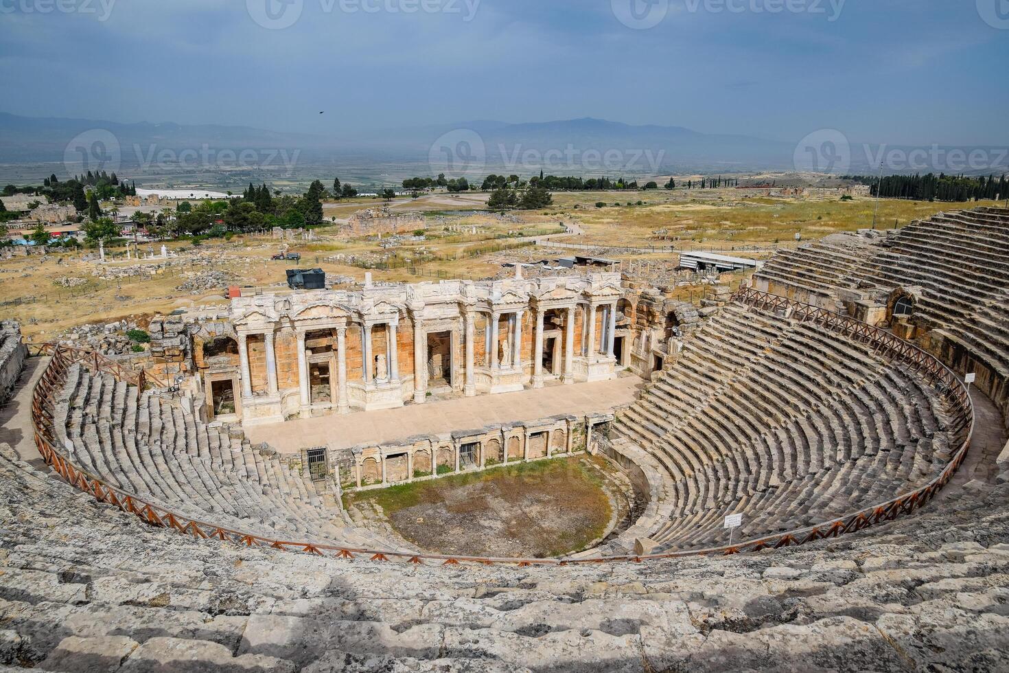 Ancient antique amphitheater in city of Hierapolis in Turkey. Steps and antique statues with columns in the amphitheater photo