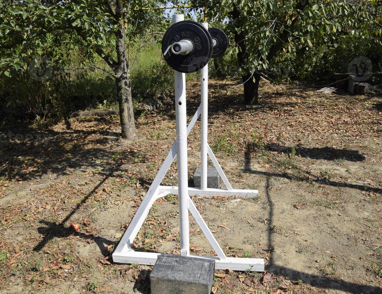 Homemade rod racks. Sports equipment in the backyard. Weightlifting bar. photo