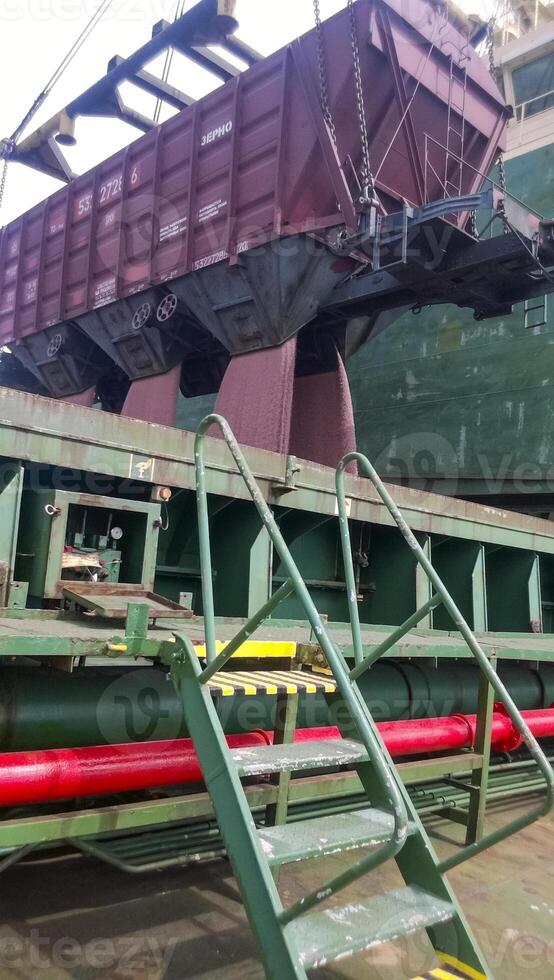 The precipitation of grain from the car into the hold of the tanker. Grain filling of the cargo compartment of the ship. photo