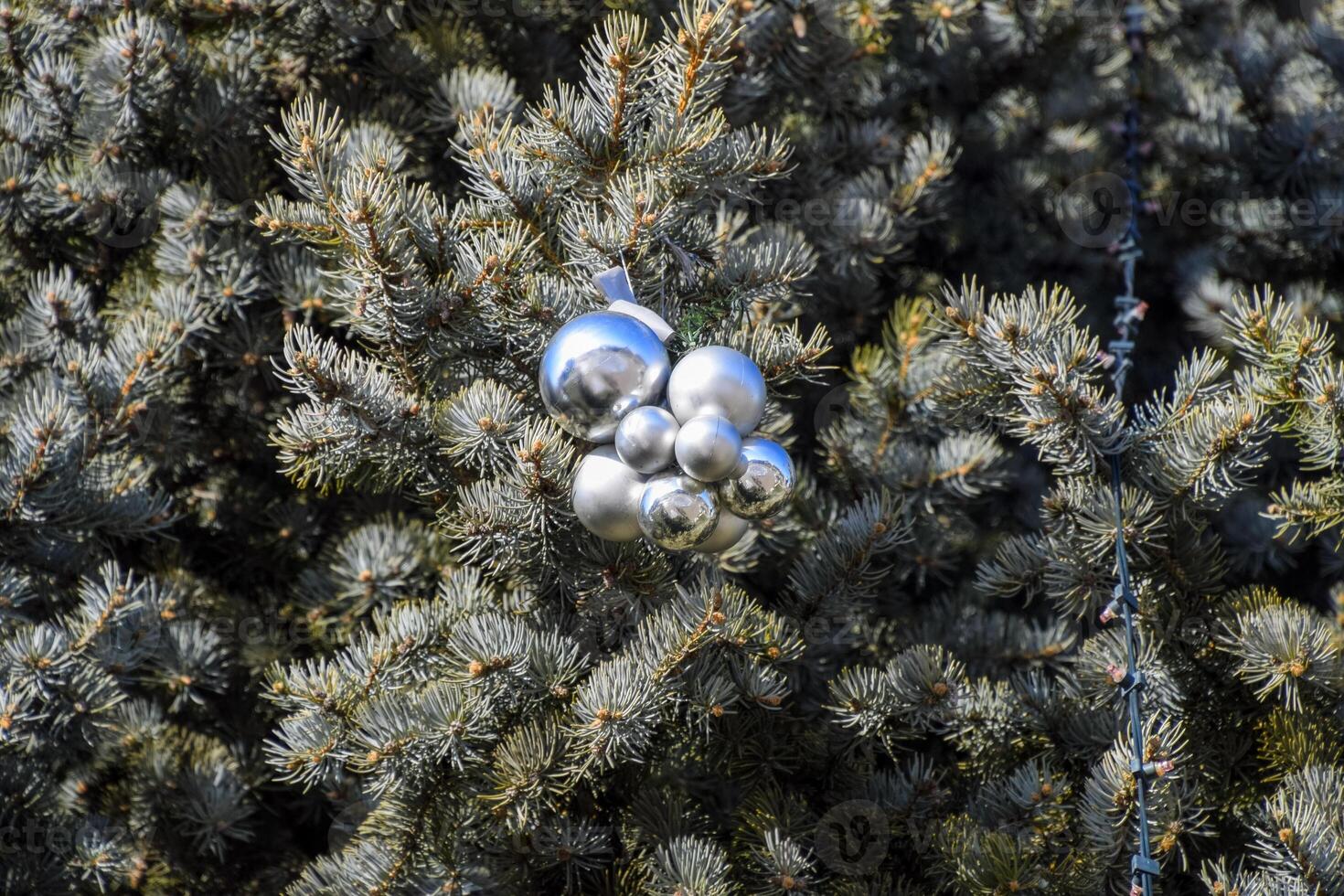 Decorations New Year tree. Tinsel and toys, balls and other decorations on the Christmas Christmas tree standing in the open air. photo