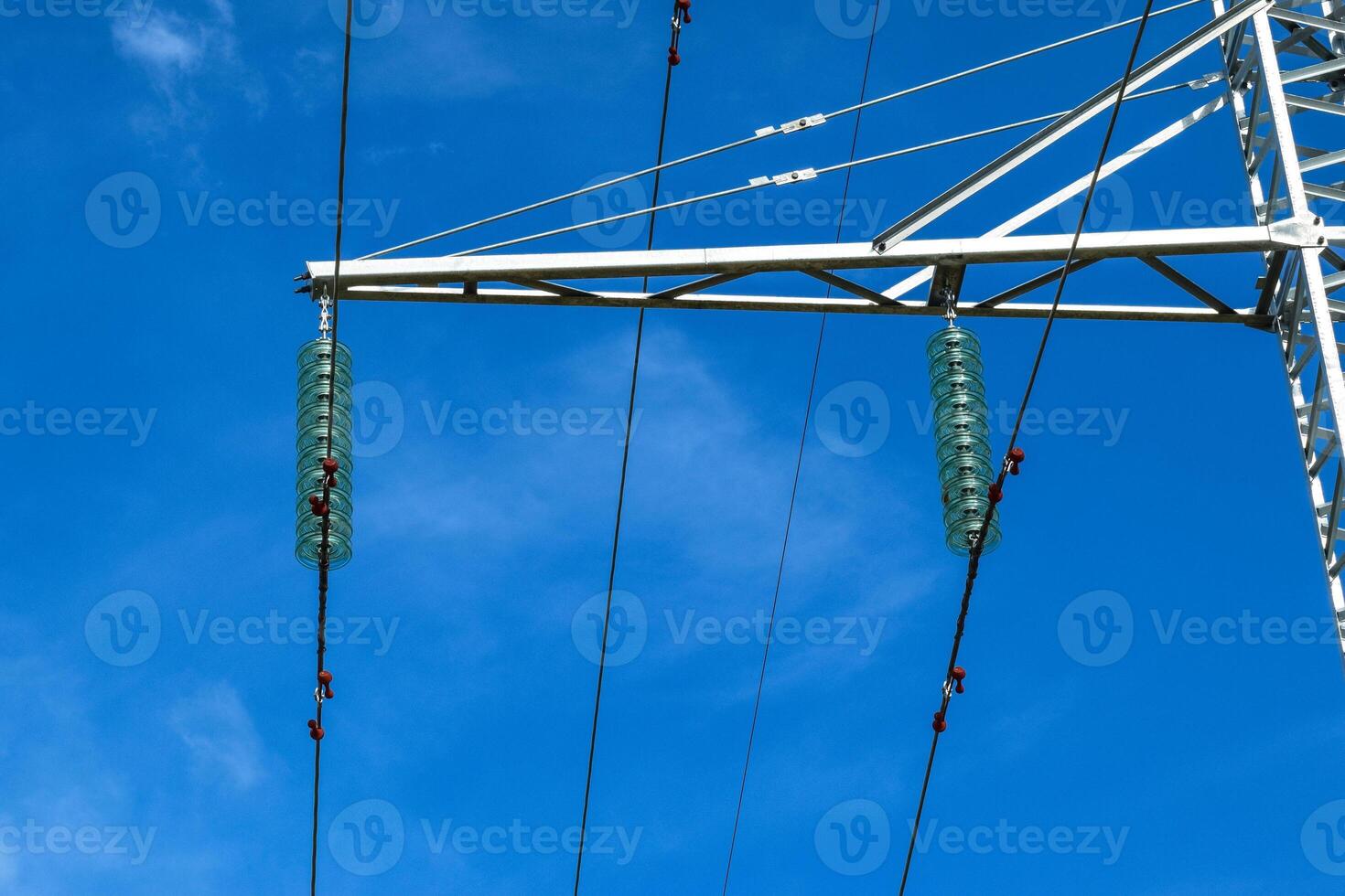 Supports high-voltage power lines against the blue sky with clouds. Electrical industry photo