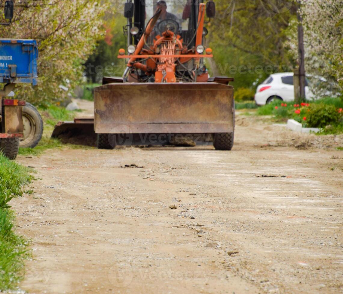 calificador en un suciedad grava la carretera. calle reparar por agregando escombros. foto