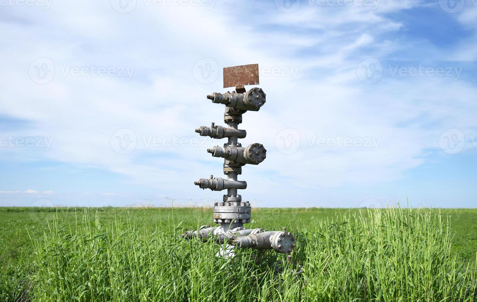 Canned oil well against the sky and field photo