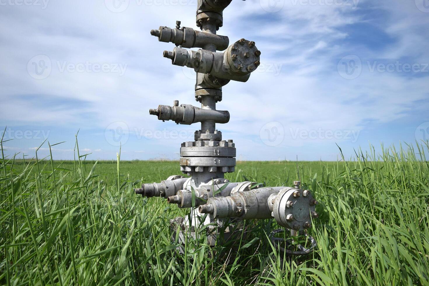 Enlatado petróleo bien en contra el cielo y campo foto