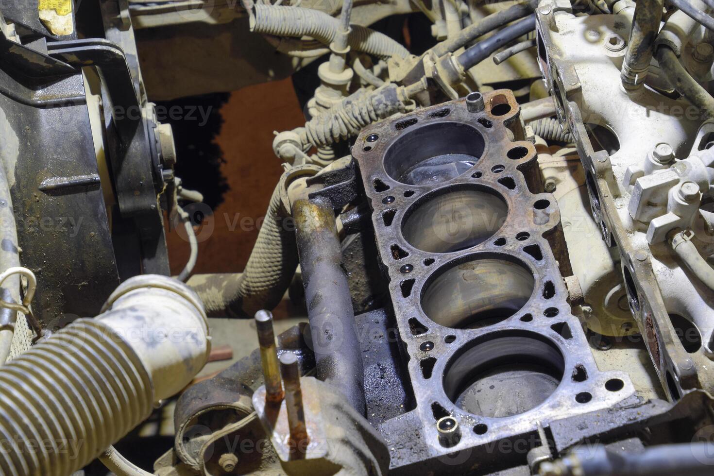 The cylinder block of the four-cylinder engine. Disassembled motor vehicle for repair. Parts in engine oil. Car engine repair in the service photo