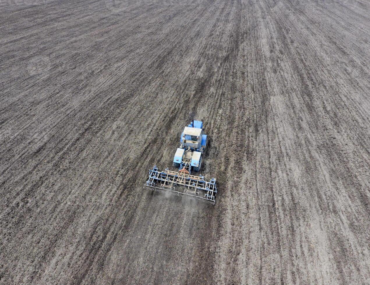 Cultivation of soil for the sowing of cereals. Tractor plows the soil on the field photo