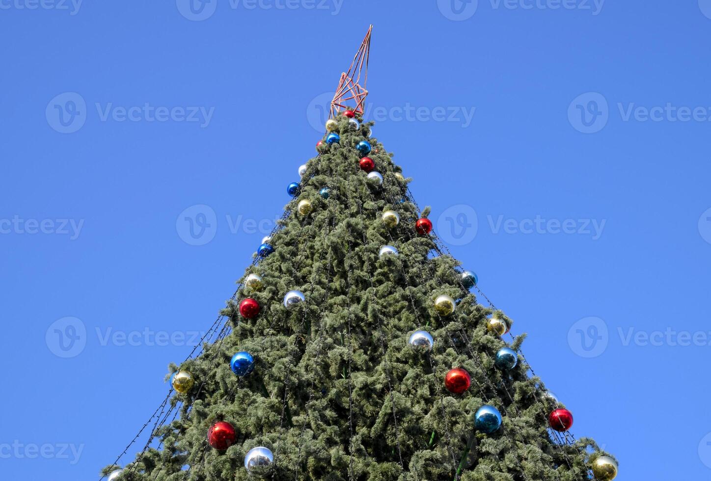 Decorations New Year tree. Tinsel and toys, balls and other decorations on the Christmas Christmas tree standing in the open air. photo