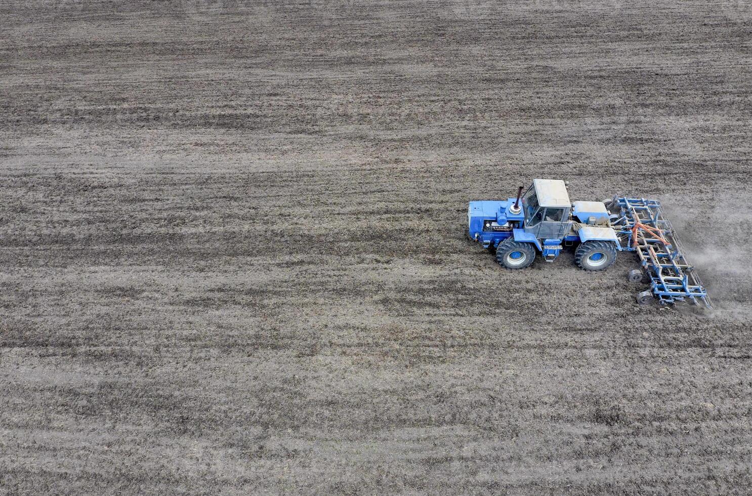Cultivation of soil for the sowing of cereals. Tractor plows the soil on the field photo