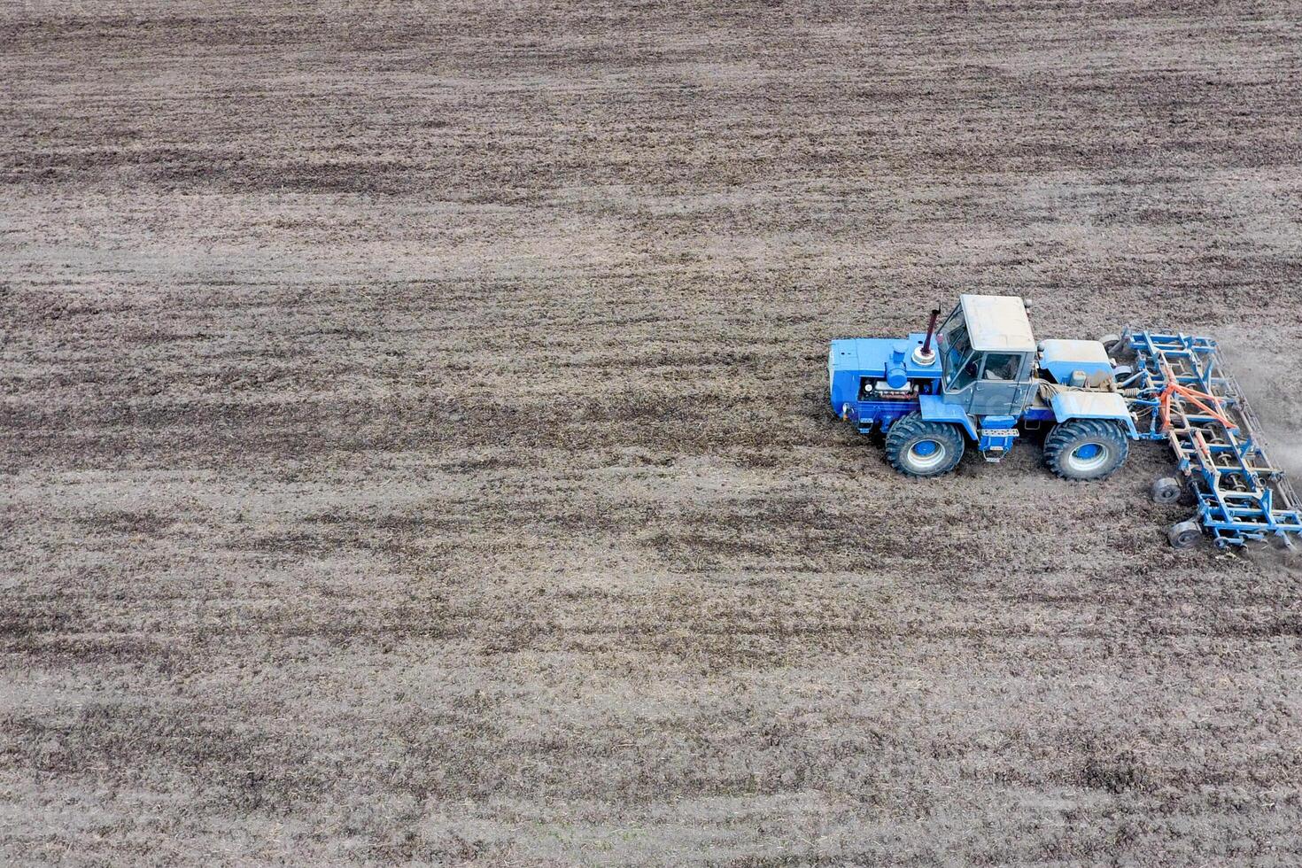 Cultivation of soil for the sowing of cereals. Tractor plows the soil on the field photo