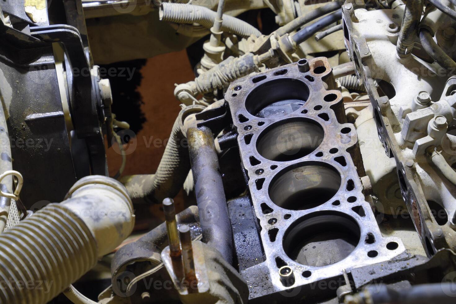 The cylinder block of the four-cylinder engine. Disassembled motor vehicle for repair. Parts in engine oil. Car engine repair in the service photo