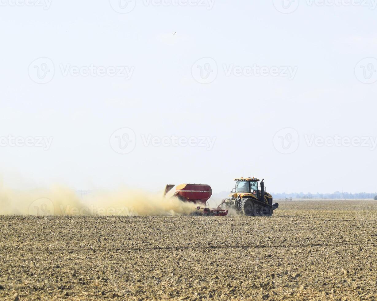 tractor paseos en el campo y hace el fertilizante dentro el asique foto