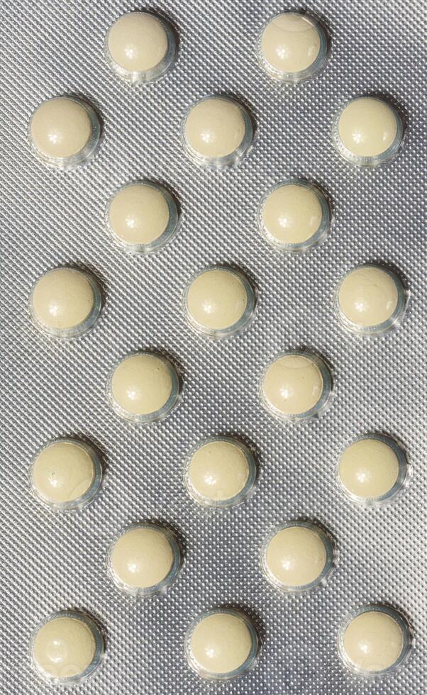 Blister pack with round yellow pills, top view photo