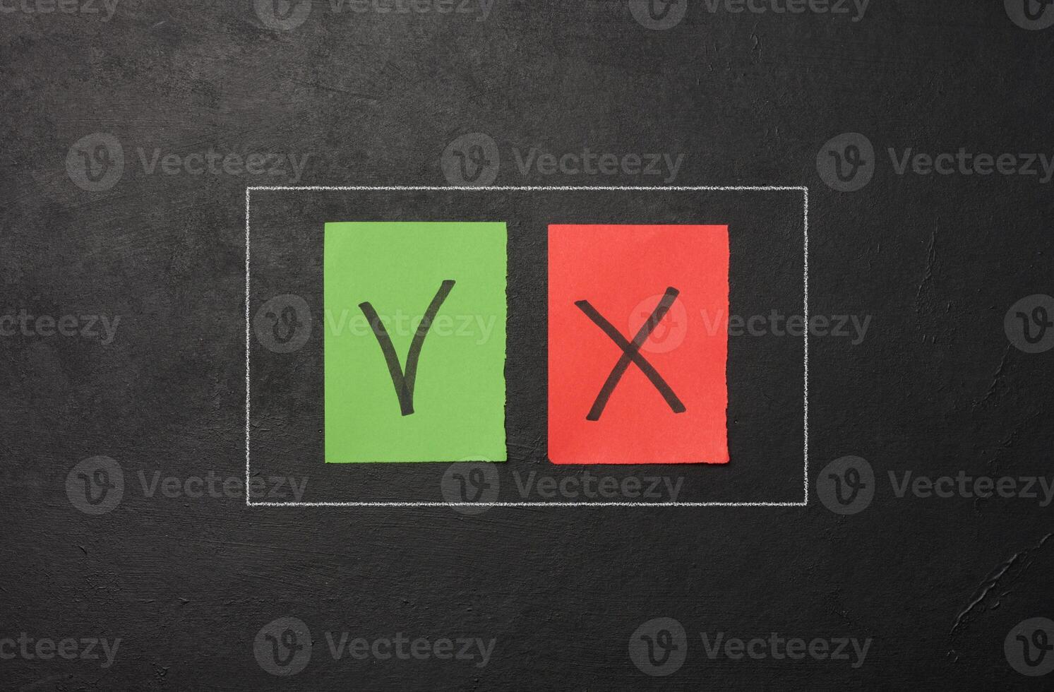 Two paper sheets with drawn check mark and cross symbols, representing the concept of error and correction photo